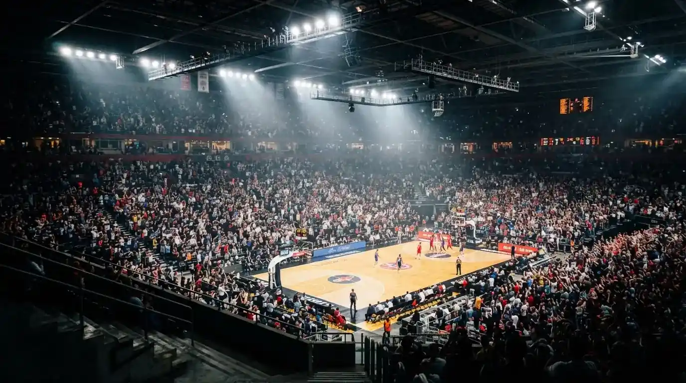 A packed sports hall under floodlights photographed from a long way off